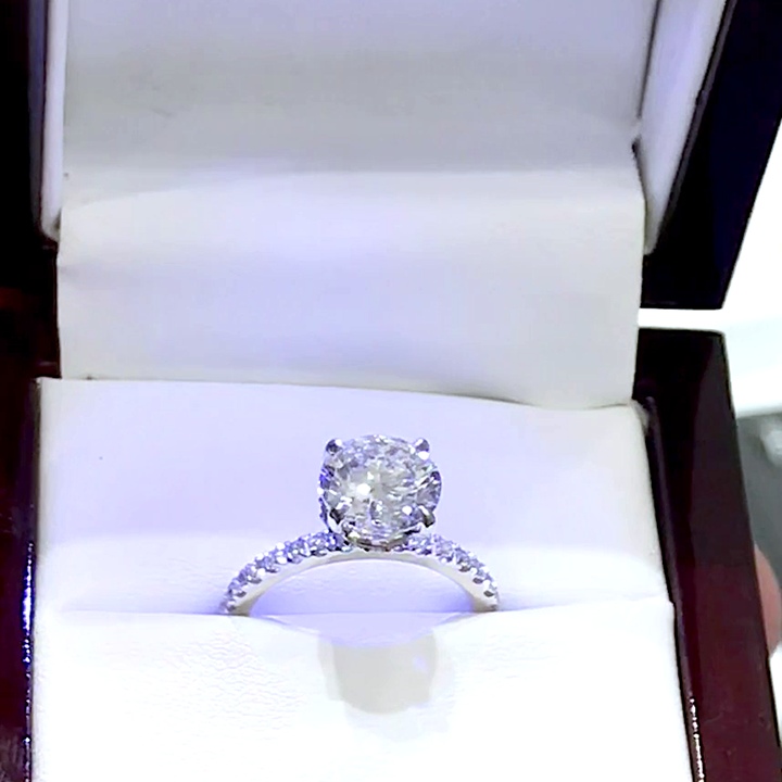 18kt White Gold Engagement Ring with 1.7 carat lab diamond at the center (Color: E | Clarity: VVS2 | Round Cut). Setting Diamonds are natural (E/VVS). Hidden Halo Setting with Pave Set Diamonds on the Shank.